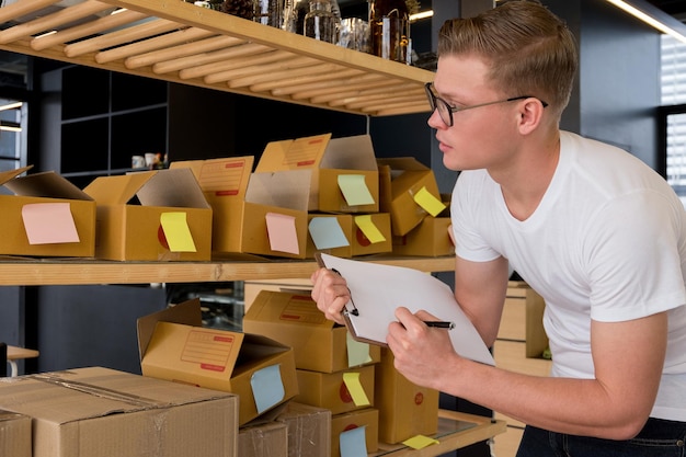 Photo man analyzing boxes in factory