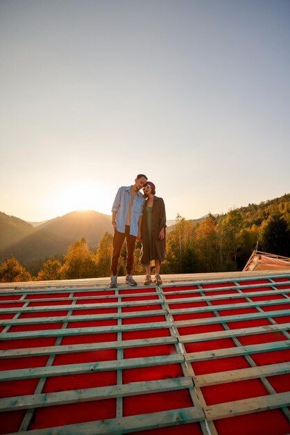 Фото Мужчина и женщина наслаждаются красивым закатом солнца в горах
