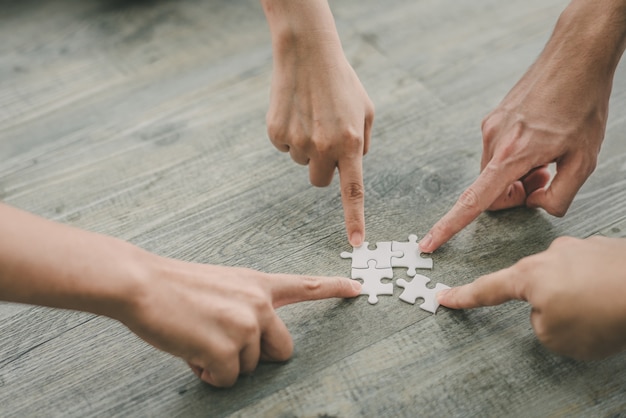 写真 ジグソーパズルのパズルを一緒に入れている男と女の手