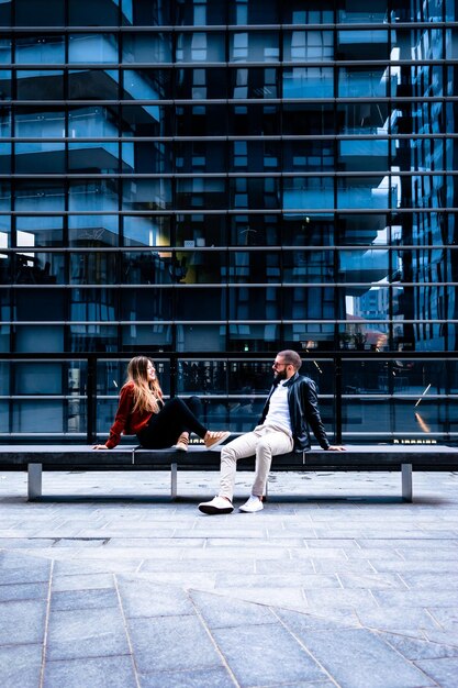 写真 男性と女性が街の建物の反対側に座っています