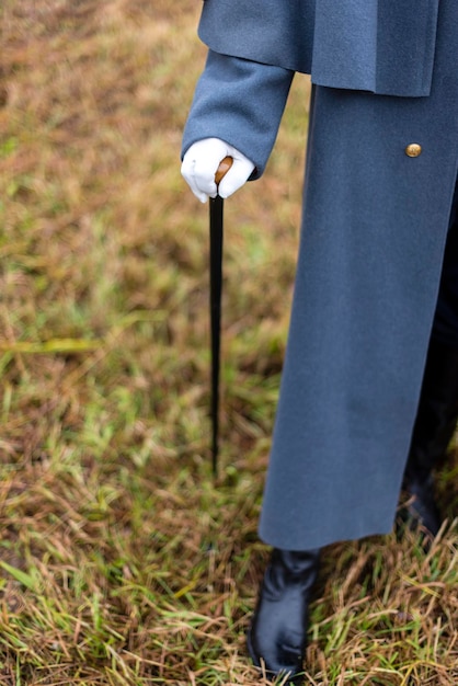 A man in antique clothes holds a cane