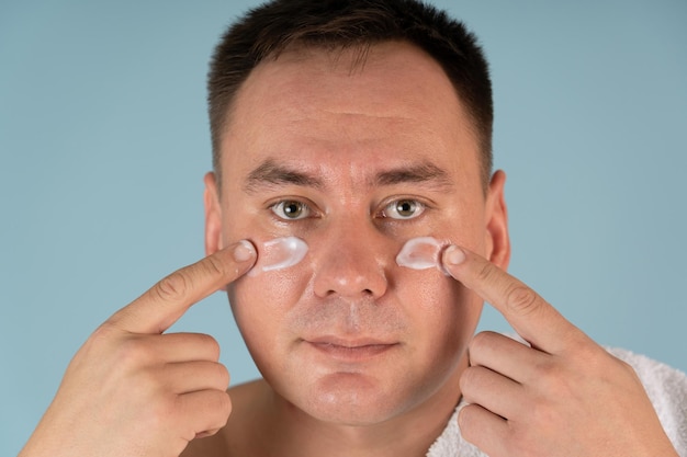 A man applies a face cream. Skin care