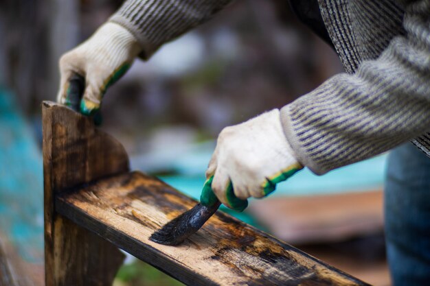 A man applies paint to a wooden surface with a brush Lacquer work