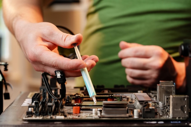 Foto l'uomo applica la pasta termica alla cpu