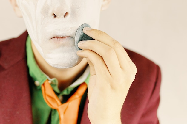 Man apply makeup the clown is painting his face