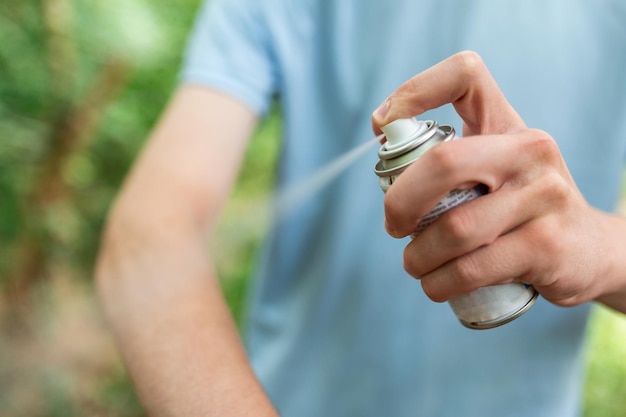 自然の中でのハイキング中に蚊とダニに対して虫除けを適用している男性虫刺されに対する皮膚の保護