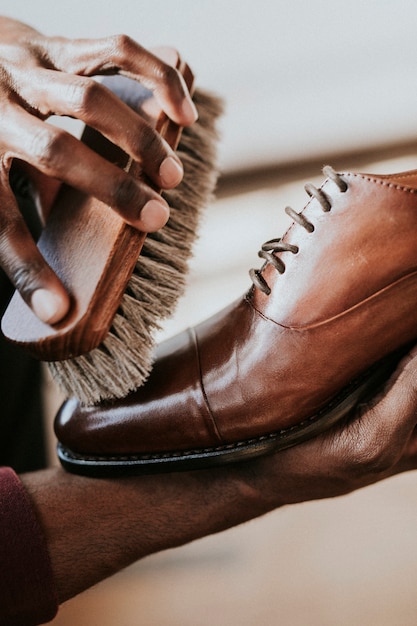 Man applying shoe polish to his brown leather shoes