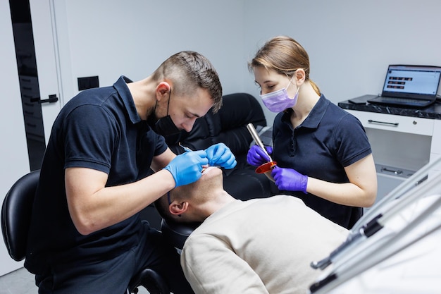 Мужчина на приеме у ортодонта ортодонтическое лечение зубов Современный медицинский ортодонтический кабинет Стоматологическая помощь