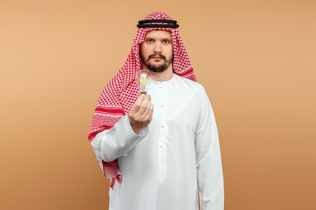 A man Arab holds a national costume holding a light bulb in his hand. Concept idea, thought.