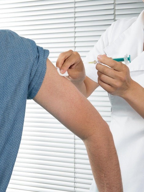 Man arm vaccin injectie met een spuit in ziekenhuisflacon covid-19 coronavirus vaccins ampul