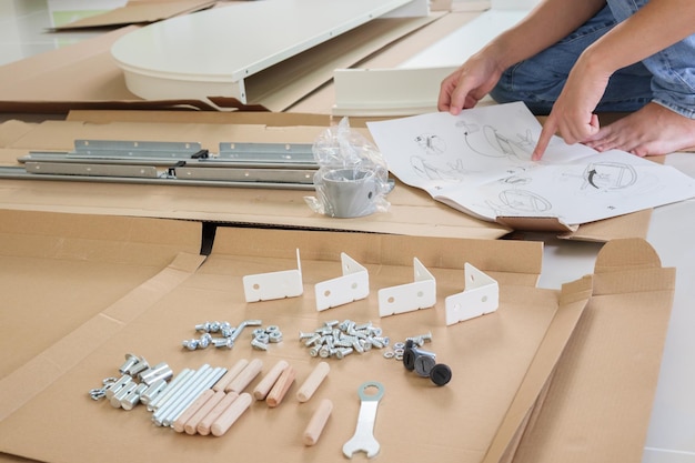 Man assembleert witte ronde tafelmeubels thuis