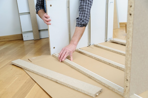 Man assembling furniture from chipboard boards