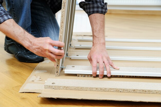 Man assembling furniture from chipboard boards