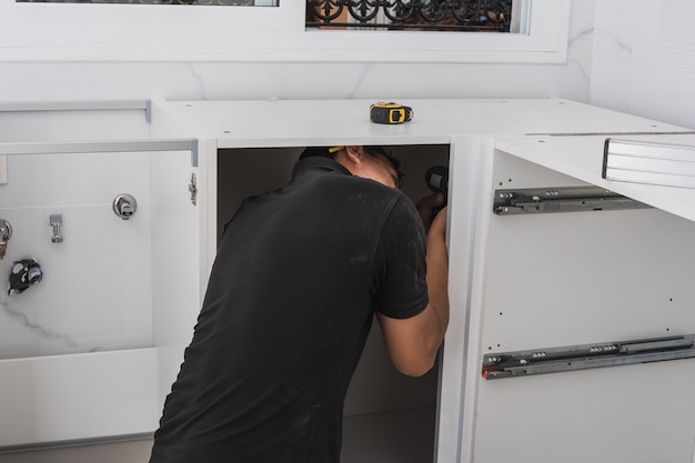 Man assembling a kitchen cabinet