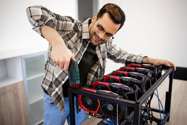 Uomo che monta il nuovo impianto di mining bitcoin