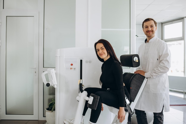 Man assisting woman training in rehabilitation center