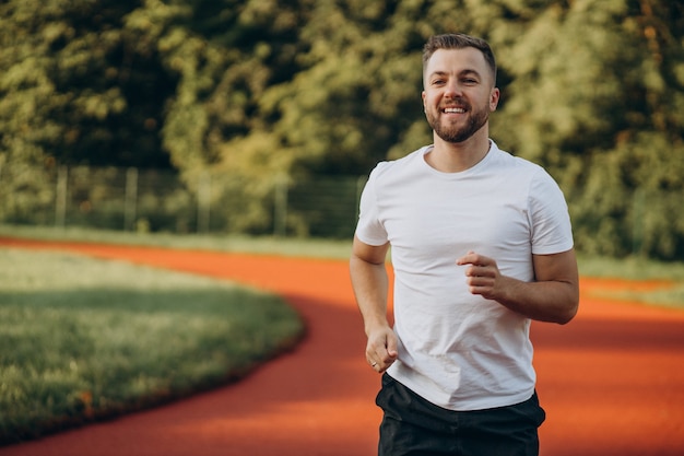 Man athlete jogging at stadium in the morning