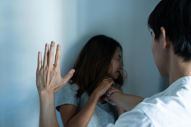 A man attacking to a scared young asian woman in a dark place\
stop sexual abuse concept