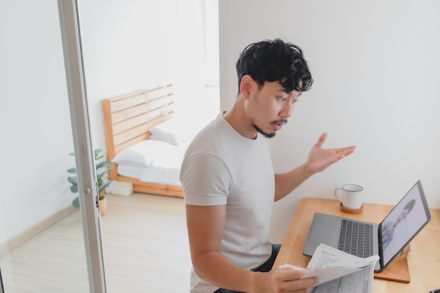 Man attend a meeting conference with his colleague while work from home