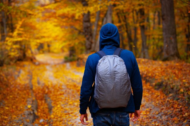 Man in autumn forest road