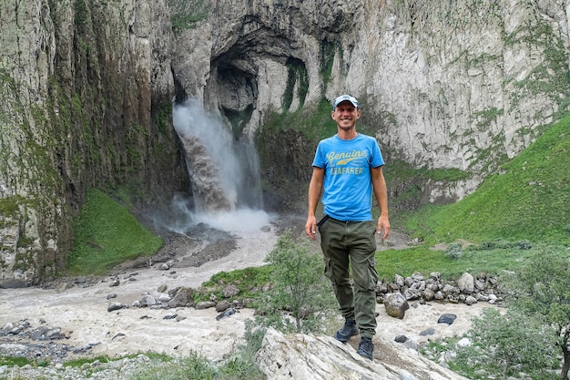 KabardinoBalkaria 백인 러시아 영토에 있는 TuzlukShapa 폭포 배경에 있는 남자