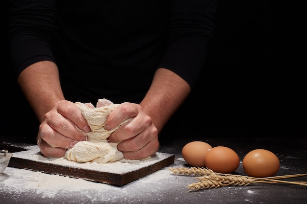 Man Baker en zijn handen over het brood van volkoren meel