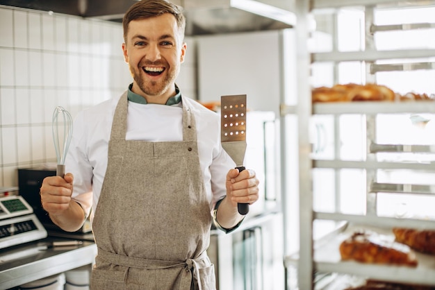 Man bakker met garde en spatel