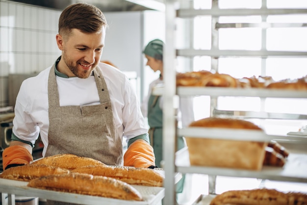 Man bakker met vers brood bij bakkershuis