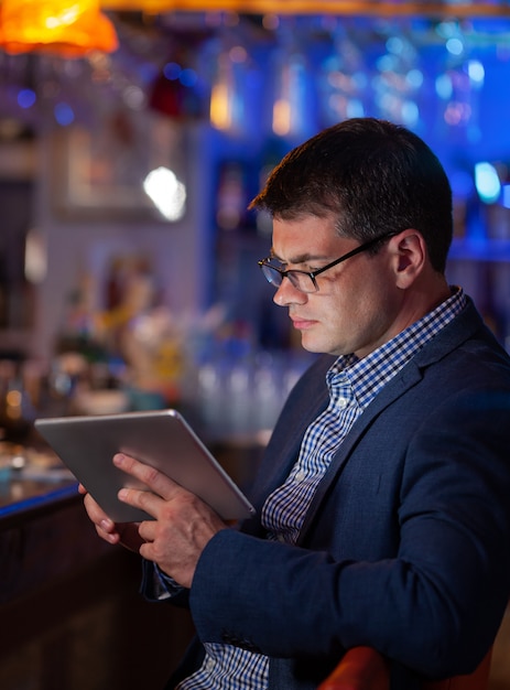 Man at the bar looking at the digital tablet