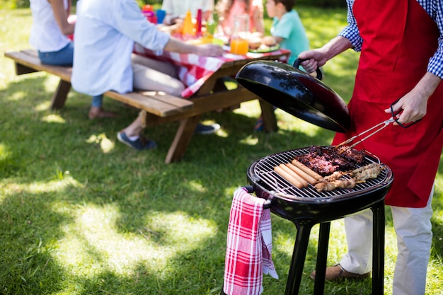 Uomo che barbequing nel parco