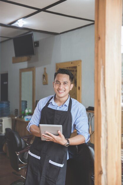 Man in barbershop with digital tablet