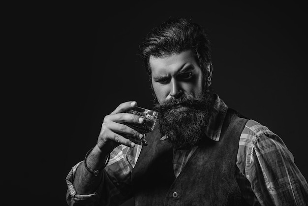 Man bartender holding glass of whisky man or businessman drinks whiskey on black background degustat