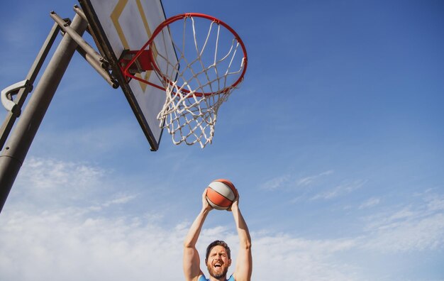 Man basketball player sportsman in shirt and shorts hold basketball ball on urban background sport m