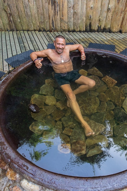 Man bathing in cast iron vat with mineral water containing hydrogen sulphide