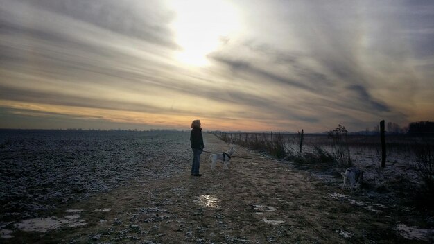 Foto uomo sulla spiaggia contro il cielo durante il tramonto