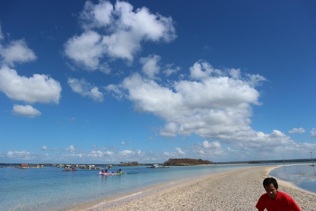 Foto uomo sulla spiaggia contro il cielo