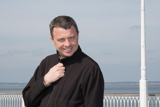 Man next to the  beach and the  sea smiling