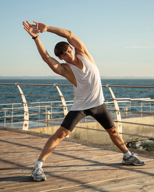 Man at the beach stretching and exercising