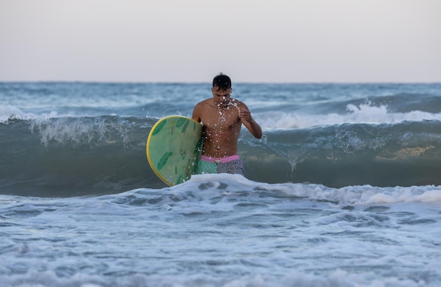 man on the beach with surfboard