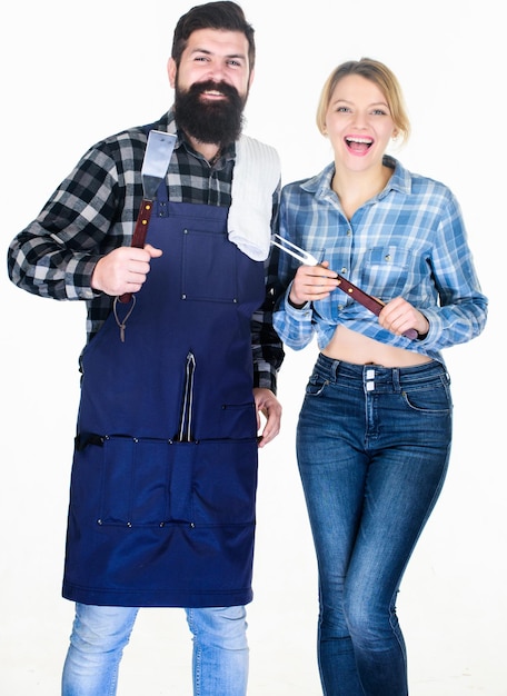 Man bearded hipster and girl Preparation and culinary Family weekend Couple in love hold kitchen utensils Tools for roasting meat Picnic barbecue food cooking recipe Helpful technology