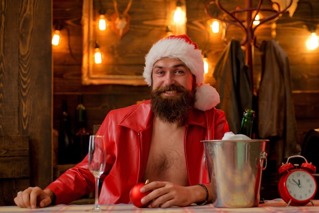 Man bearded hipster santa with red hat celebrate with champagne drink. Christmas holiday. Lonely on christmas eve. Happy new year. Time to drink. Manly brutal santa leather jacket. Brutal santa claus.