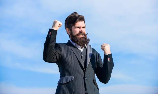 Photo man bearded optimistic businessman wear formal suit sky background success and luck optimistic mood think like optimist being optimistic celebrate success hopeful and confident about future