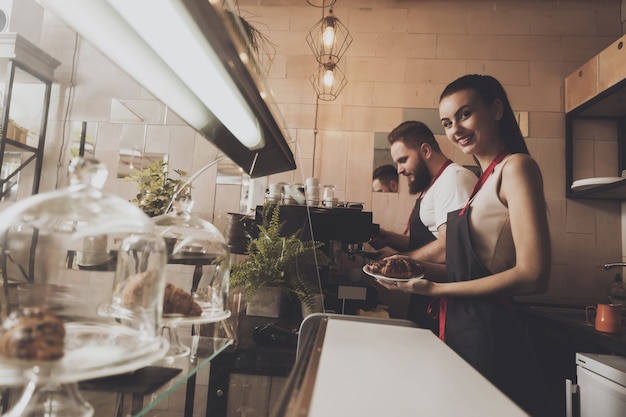 Man and beautiful girl barista behind the counter