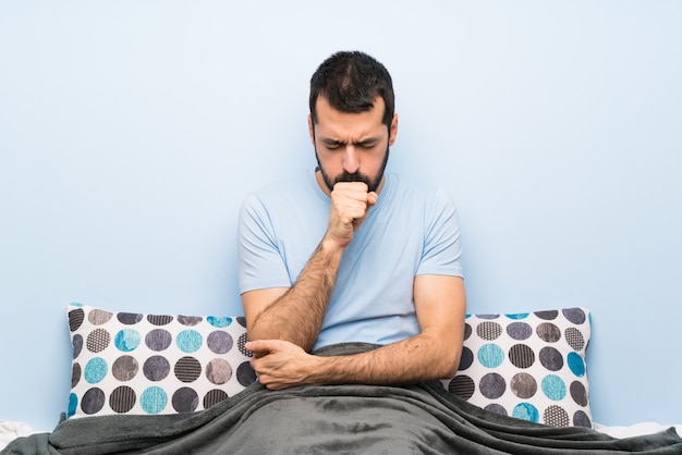 Man in bed is suffering with cough and feeling bad