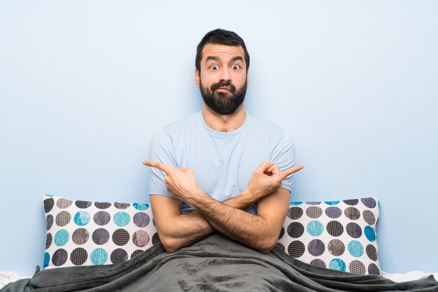 Man in bed pointing to the laterals having doubts