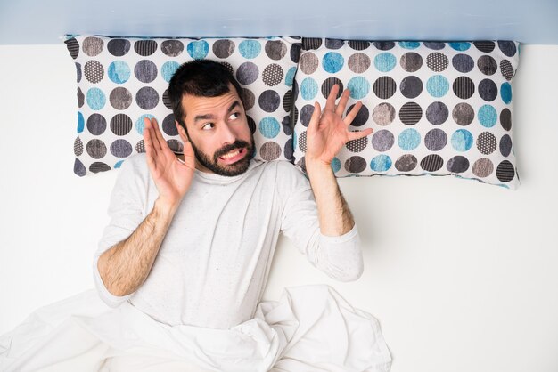 Man in bed in top view nervous and scared