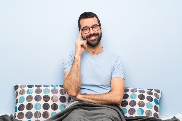 Man in bed with glasses and happy