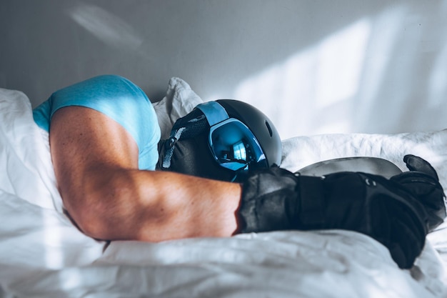 스노보드 스키 구글과 헬멧을 쓴 침대에 누워 있는 남자