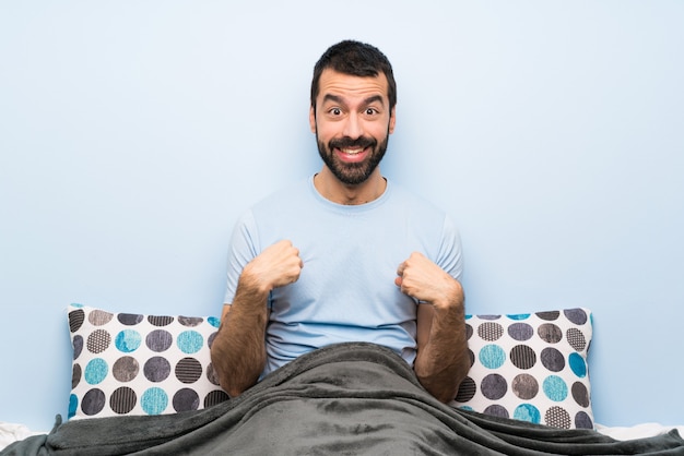 Man in bed with surprise facial expression