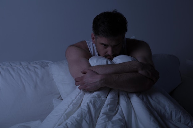 Man in bed with a white shirt and a white shirt